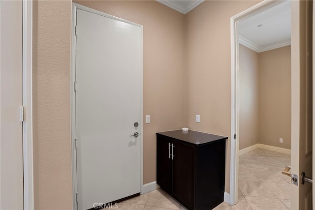 interior space featuring crown molding, baseboards, and tile patterned floors