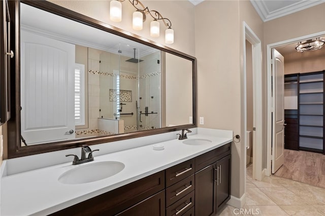 bathroom with double vanity, a stall shower, a sink, and crown molding