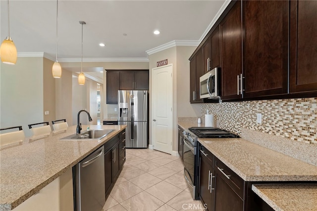 kitchen featuring dark brown cabinetry, a sink, appliances with stainless steel finishes, backsplash, and decorative light fixtures