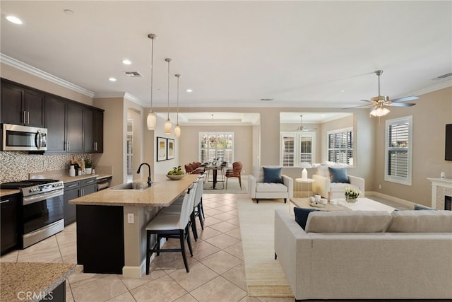 kitchen with visible vents, decorative backsplash, open floor plan, stainless steel appliances, and a sink