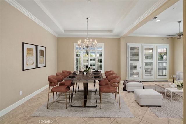 dining room featuring plenty of natural light, a tray ceiling, baseboards, and ceiling fan with notable chandelier