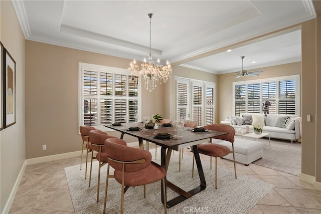 dining room featuring baseboards, a tray ceiling, crown molding, and ceiling fan with notable chandelier