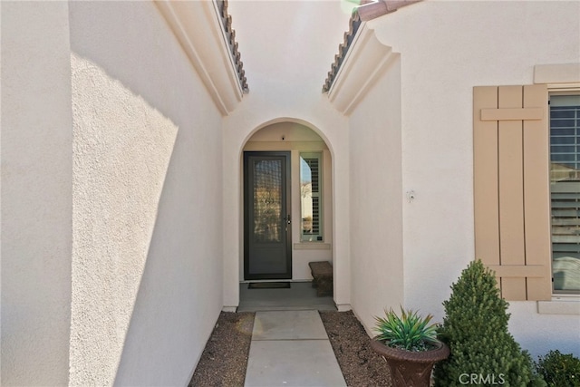 view of exterior entry featuring stucco siding