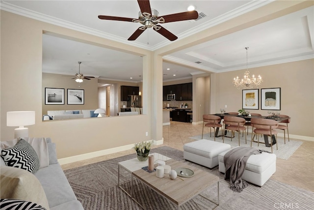 living area featuring a notable chandelier, a tray ceiling, ornamental molding, and baseboards