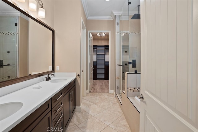 bathroom with double vanity, ornamental molding, a sink, and a shower stall