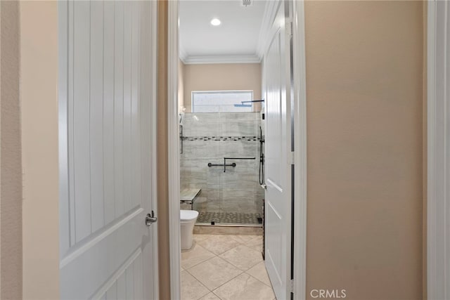 bathroom with tile patterned flooring, a shower stall, toilet, and crown molding