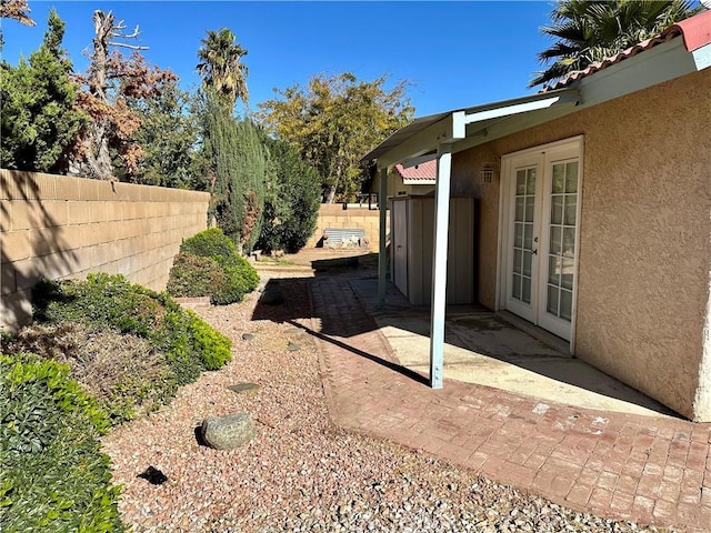 view of yard featuring a patio area, fence, and french doors