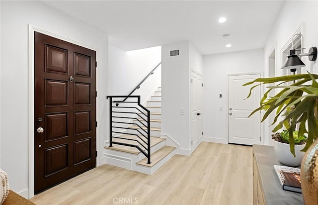 entryway with recessed lighting, visible vents, baseboards, stairs, and light wood-style floors