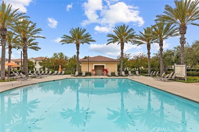 pool with a patio area and fence