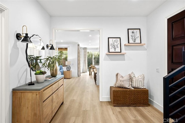 hallway with light wood-type flooring, baseboards, and recessed lighting