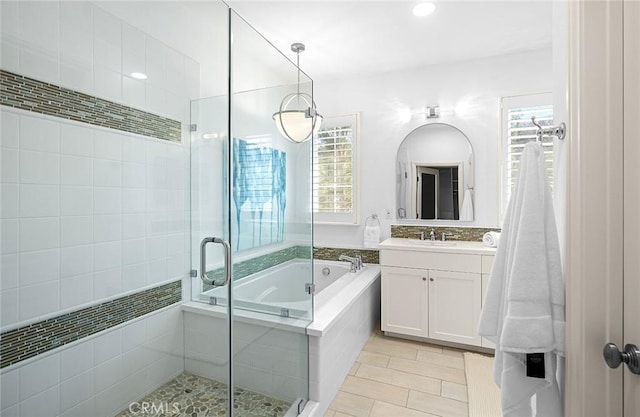 bathroom with a stall shower, vanity, a bath, and tile patterned floors