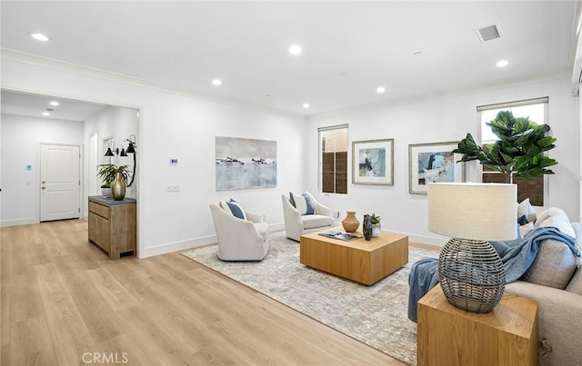 living room featuring light wood-style floors, baseboards, visible vents, and recessed lighting