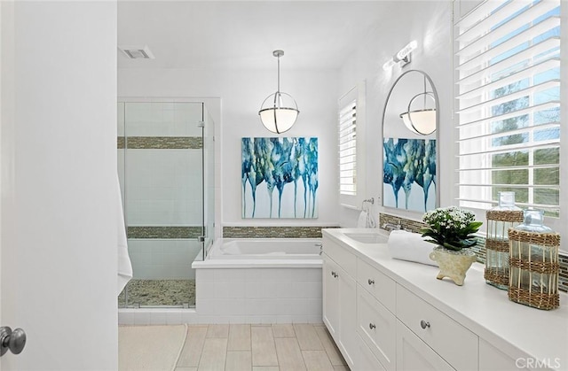 bathroom featuring visible vents, a shower stall, vanity, and a bath