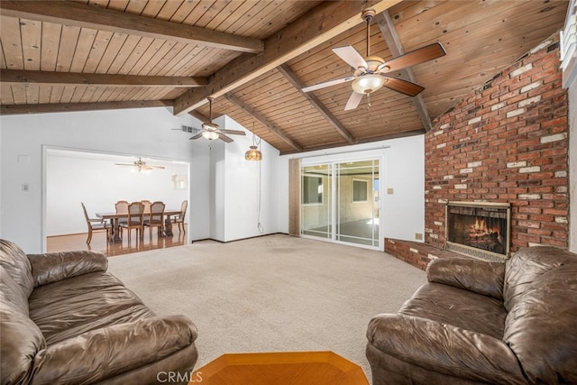 living area featuring lofted ceiling with beams, a brick fireplace, wood ceiling, and carpet flooring