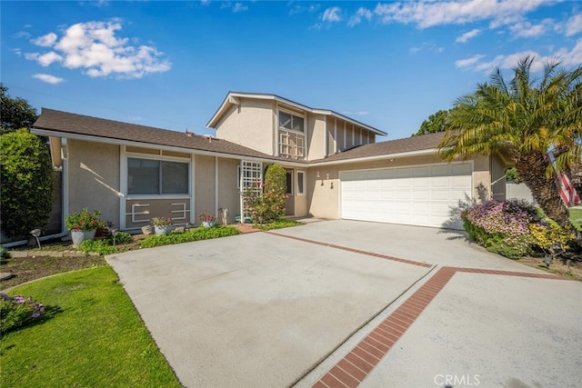 traditional-style house featuring a garage, concrete driveway, and stucco siding