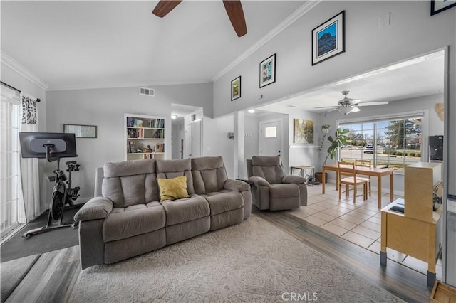 living area featuring ceiling fan, wood finished floors, visible vents, vaulted ceiling, and crown molding