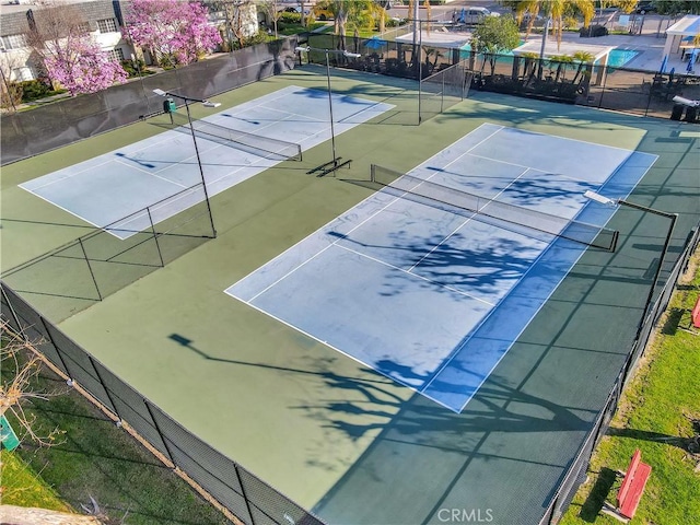 view of tennis court featuring fence