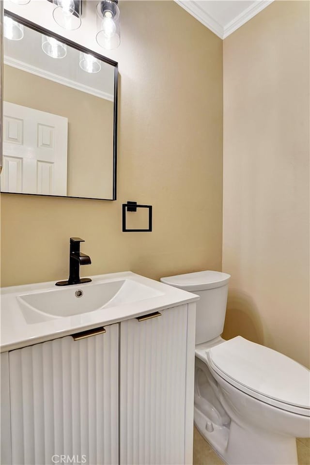 half bathroom featuring vanity, toilet, and crown molding