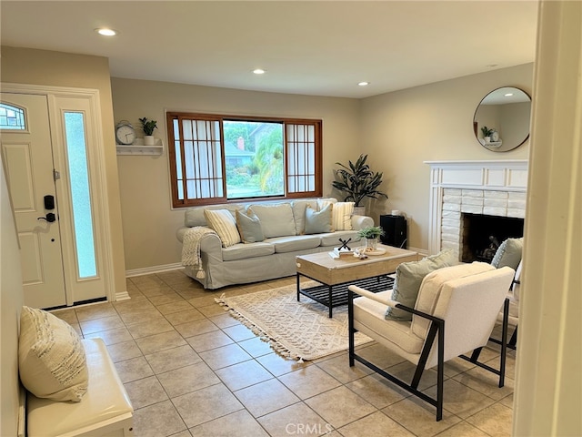 living room featuring light tile patterned floors, recessed lighting, baseboards, and a tile fireplace