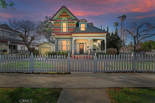 victorian house with a porch and a fenced front yard