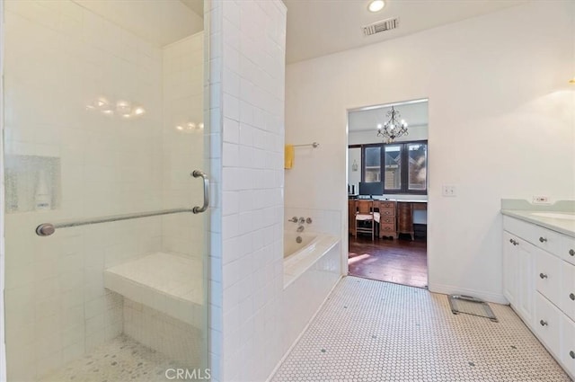 full bathroom featuring vanity, visible vents, baseboards, a bath, and a stall shower