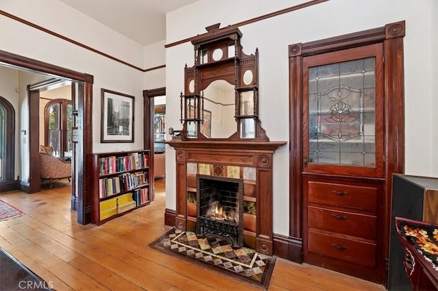 living area with a wealth of natural light, a fireplace with flush hearth, and hardwood / wood-style flooring