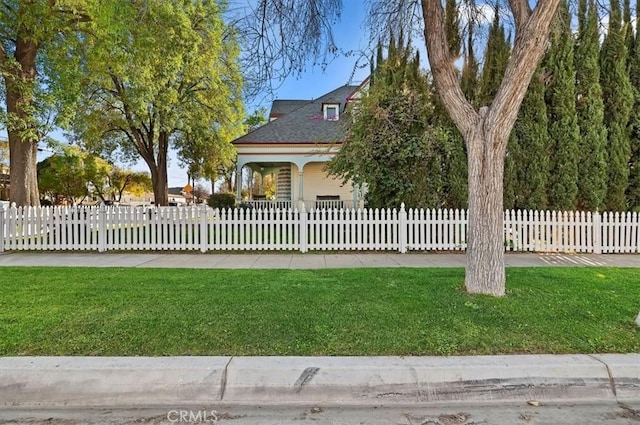 view of front of house with a fenced front yard and a front lawn