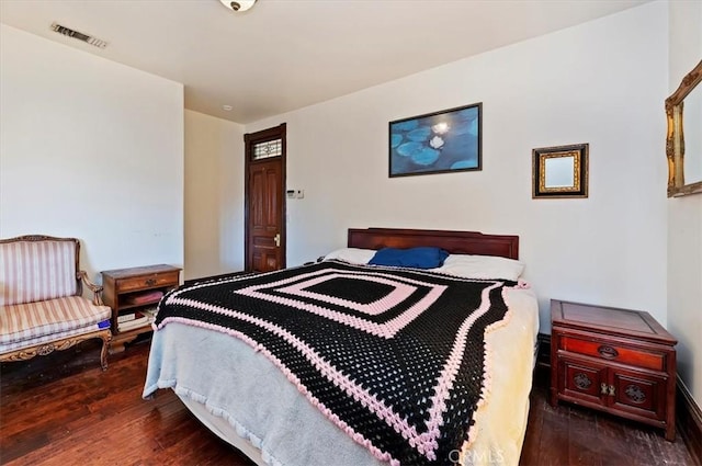 bedroom featuring wood finished floors and visible vents