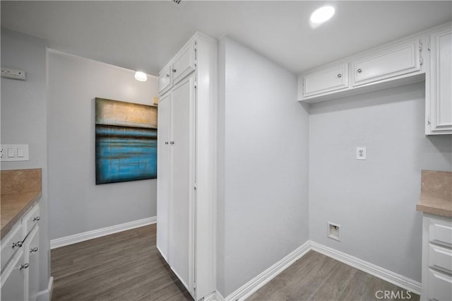 laundry room with dark wood-style floors and baseboards