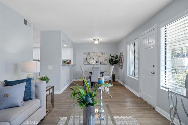 interior space featuring baseboards, visible vents, and wood finished floors