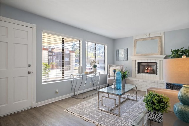 living area with a fireplace, wood finished floors, and baseboards