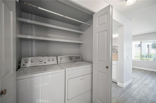 laundry area featuring light wood-type flooring, laundry area, baseboards, and washing machine and clothes dryer