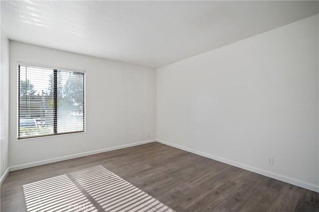 unfurnished room featuring baseboards and wood finished floors