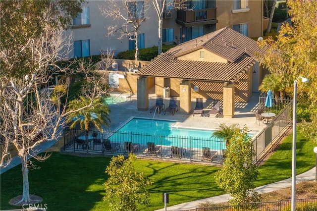 pool featuring a patio area, fence, and a lawn