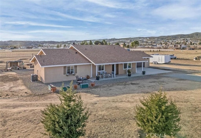 rear view of property featuring a patio area, central AC, and stucco siding