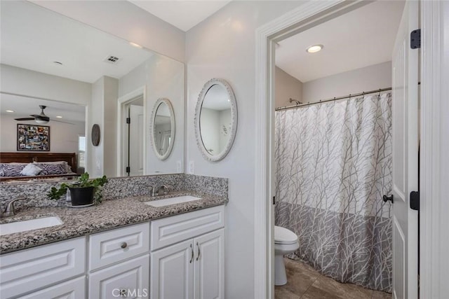 full bathroom featuring toilet, double vanity, a sink, and visible vents