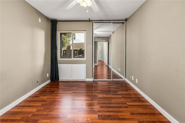 unfurnished room featuring wood finished floors, a ceiling fan, and baseboards