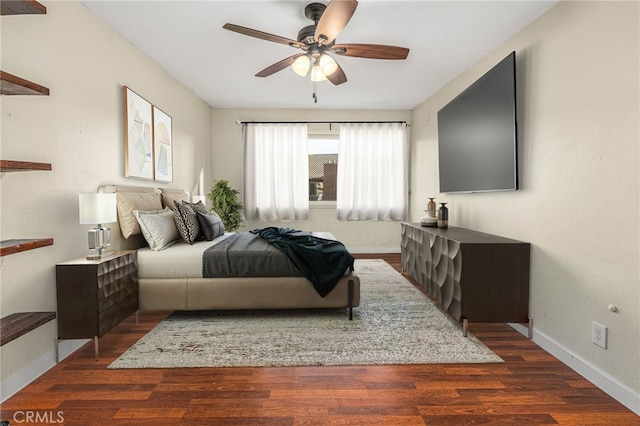 bedroom with a ceiling fan, baseboards, and wood finished floors