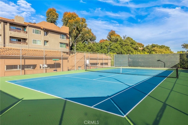 view of tennis court featuring fence