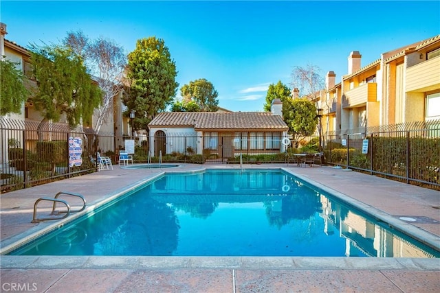 pool with a patio area and fence