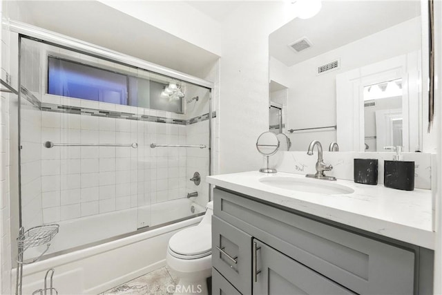 bathroom with toilet, visible vents, bath / shower combo with glass door, and vanity