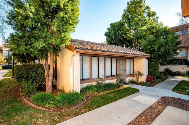 mediterranean / spanish home with a tiled roof and stucco siding