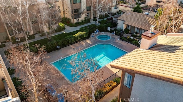 view of pool featuring fence and a hot tub