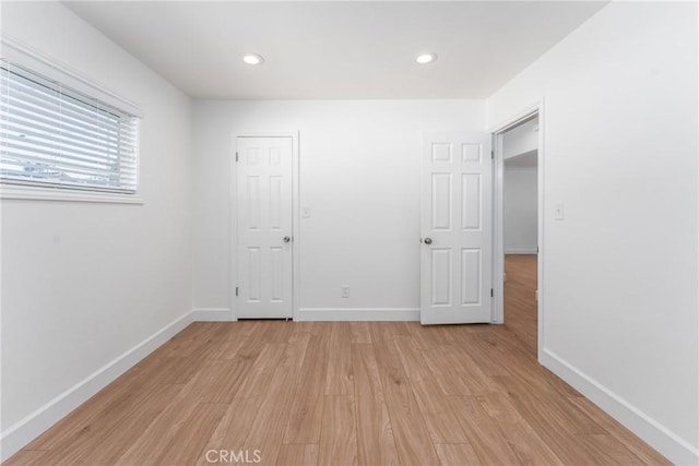 unfurnished bedroom featuring light wood-type flooring, baseboards, and recessed lighting