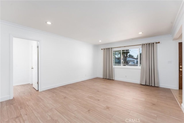 spare room with baseboards, light wood-type flooring, and crown molding