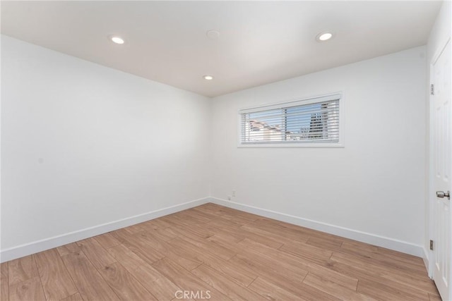 unfurnished room with baseboards, recessed lighting, and light wood-style floors