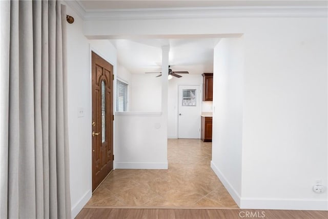 hall featuring baseboards, crown molding, and light tile patterned flooring