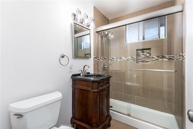 bathroom featuring a stall shower, vanity, and toilet