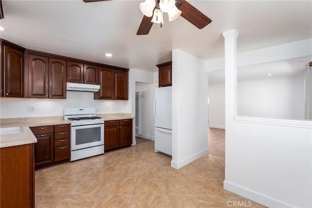 kitchen with recessed lighting, white appliances, light countertops, and under cabinet range hood