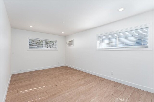 spare room with light wood finished floors, baseboards, and a wealth of natural light